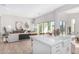 Open-concept living space with a modern kitchen island, comfortable seating, and expansive windows offering abundant natural light at 5741 E Star Valley St, Mesa, AZ 85215