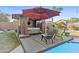 Relaxing backyard spa with a red umbrella providing shade, creating a perfect spot for outdoor relaxation at 586 E Stirrup Ln, San Tan Valley, AZ 85143