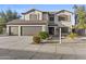 Inviting two-story home with a well-manicured front yard and three-car garage, providing ample space for vehicles at 586 E Stirrup Ln, San Tan Valley, AZ 85143