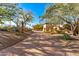 Desert home on a long driveway, landscaped with mature trees and desert plants at 6602 N 40Th St, Paradise Valley, AZ 85253