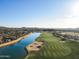 Scenic aerial view of a lush golf course community with a lake and desert landscaping at 8057 E Greythorn Dr, Gold Canyon, AZ 85118