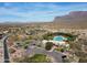 Aerial view of a community pool, tennis courts, and desert landscape with mountain backdrop at 8057 E Greythorn Dr, Gold Canyon, AZ 85118