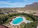 Aerial view of community pool, tennis courts, and desert landscape with mountain backdrop at 8057 E Greythorn Dr, Gold Canyon, AZ 85118
