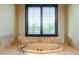 Luxurious bathroom with tile-surround tub and window with wood shutters, offering a relaxing spa-like experience at 8057 E Greythorn Dr, Gold Canyon, AZ 85118