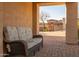 Cozy covered patio with comfortable seating, offering a peaceful view of the front yard and neighborhood at 8057 E Greythorn Dr, Gold Canyon, AZ 85118