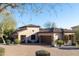 Charming single-Gathering home featuring a brick driveway, desert landscaping, and a two-car garage at 8057 E Greythorn Dr, Gold Canyon, AZ 85118