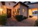 Inviting front entrance with a dark wood door, desert landscaping, and warm lighting that creates an appealing welcome at 8057 E Greythorn Dr, Gold Canyon, AZ 85118