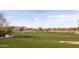 Scenic view of the golf course with lush green grass, sand traps, and golf carts in the distance at 8057 E Greythorn Dr, Gold Canyon, AZ 85118