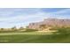 Picturesque golf course with challenging sand traps, lush green, and stunning mountain views in the background at 8057 E Greythorn Dr, Gold Canyon, AZ 85118