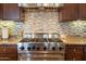 Close up of kitchen range, mosaic backsplash and granite countertops at 8057 E Greythorn Dr, Gold Canyon, AZ 85118