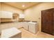 Bright laundry room featuring a large counter, cabinetry, sink, washer and dryer, and tile flooring at 8057 E Greythorn Dr, Gold Canyon, AZ 85118