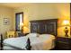 A stunning main bedroom featuring a king bed, bedside tables, lamps, and plantation shutters at 8057 E Greythorn Dr, Gold Canyon, AZ 85118