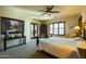 This main bedroom features a king bed, plantation shutters, bedside tables, and a ceiling fan at 8057 E Greythorn Dr, Gold Canyon, AZ 85118