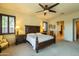 This bedroom features a ceiling fan, a king bed, plantation shutters, and bedside tables with lamps at 8057 E Greythorn Dr, Gold Canyon, AZ 85118
