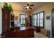 Home office with rich wood built-ins, neutral walls and a window with plantation shutters at 8057 E Greythorn Dr, Gold Canyon, AZ 85118