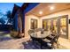 Covered patio featuring an outdoor dining table and chairs, with views of the landscaped backyard and architectural details at 8057 E Greythorn Dr, Gold Canyon, AZ 85118