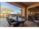 Outdoor dining space overlooking the pool, complete with seating, a water feature, and desert landscaping at 8057 E Greythorn Dr, Gold Canyon, AZ 85118