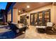 Stylish covered patio with comfortable seating, a ceiling fan, and access to the home through elegant French doors at 8057 E Greythorn Dr, Gold Canyon, AZ 85118