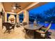Inviting covered patio with a fireplace, grill, dining table, and lounge seating, overlooking the pool and desert landscape at 8057 E Greythorn Dr, Gold Canyon, AZ 85118