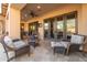 Inviting outdoor seating area on a covered patio with stylish furniture and access to the home's interior at 8057 E Greythorn Dr, Gold Canyon, AZ 85118