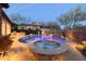 Beautiful pool and spa surrounded by desert landscaping, a stone wall, and mature trees, creating a private oasis at 8057 E Greythorn Dr, Gold Canyon, AZ 85118