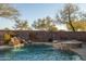 Beautiful swimming pool and spa with rock waterfall and lush landscaping for a serene backyard oasis at 8057 E Greythorn Dr, Gold Canyon, AZ 85118