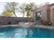 The pool has a stone waterfall flowing into it from the raised spa at 8057 E Greythorn Dr, Gold Canyon, AZ 85118