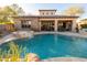 Backyard pool with the covered patio, barbeque, and desert landscaping at 8057 E Greythorn Dr, Gold Canyon, AZ 85118