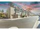 Charming townhomes with attached garages and attractive architectural details against a colorful sky at 8255 N 22Nd Dr, Phoenix, AZ 85021
