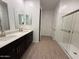 Bright bathroom featuring a double sink vanity with a walk-in shower at 9533 W Luxton Ln, Tolleson, AZ 85353