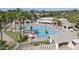 Aerial view of a large outdoor pool area with palm trees, lounge chairs, and covered seating at 9634 E Sundune Dr, Sun Lakes, AZ 85248