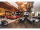 Elegant restaurant interior showcases a full bar, tables with patterned chairs, and unique lighting fixtures at 9634 E Sundune Dr, Sun Lakes, AZ 85248