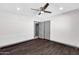 Bright bedroom features dark wood-look tile floors, ceiling fan, and closet with bi-fold doors at 9821 N 29Th Pl, Phoenix, AZ 85028