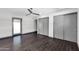 Spacious bedroom featuring dark wood floors, a ceiling fan, and gray closet doors at 9821 N 29Th Pl, Phoenix, AZ 85028