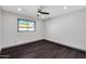 Bedroom features dark wood-look tile floors, ceiling fan, and window with a view at 9821 N 29Th Pl, Phoenix, AZ 85028