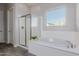 Beautiful bathroom with a separate glass shower and soaking tub under a window at 10309 E Supernova Dr, Mesa, AZ 85212