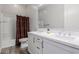 Bathroom featuring double sinks, white cabinets, and a tub with a shower behind a patterned curtain at 10309 E Supernova Dr, Mesa, AZ 85212
