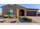 This single-story home boasts desert landscaping, an arched entry, and a two-car garage at 10309 E Supernova Dr, Mesa, AZ 85212