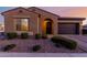 Charming single-story home featuring a desert landscape, arched entry, and a two-car garage at 10309 E Supernova Dr, Mesa, AZ 85212