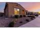 This single-story home boasts desert landscaping, an arched entry, and a two-car garage at 10309 E Supernova Dr, Mesa, AZ 85212