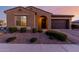 Charming single-story home featuring a desert landscape, arched entry, and a two-car garage at 10309 E Supernova Dr, Mesa, AZ 85212