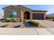 This single-story home boasts desert landscaping, an arched entry, and a two-car garage at 10309 E Supernova Dr, Mesa, AZ 85212