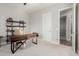 Home office with modern desk, shelving unit, carpet flooring, and a doorway at 10309 E Supernova Dr, Mesa, AZ 85212