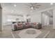 Open-concept living space with an expansive gray sectional and view to kitchen at 10309 E Supernova Dr, Mesa, AZ 85212