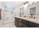 Luxurious bathroom with dual sinks, modern fixtures, and a sleek marble tile walk-in shower at 10619 W Sells Dr, Phoenix, AZ 85037