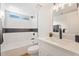 Bright bathroom with a shower and tub combination, modern fixtures, and contemporary tiling at 10619 W Sells Dr, Phoenix, AZ 85037
