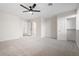 Spacious bedroom with ceiling fan and multiple doors to other rooms and closets at 10619 W Sells Dr, Phoenix, AZ 85037