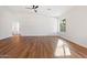 Neutral primary bedroom featuring wood-look floors, a ceiling fan, and an en-suite bathroom at 10619 W Sells Dr, Phoenix, AZ 85037