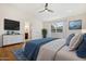 Bright main bedroom with an ensuite bathroom, dresser, television, ceiling fan and calming decor at 10619 W Sells Dr, Phoenix, AZ 85037