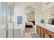 Well-lit bathroom showcasing a double vanity, modern fixtures, a tub, and an arched doorway to the bedroom at 1619 E Beretta Pl, Chandler, AZ 85286
